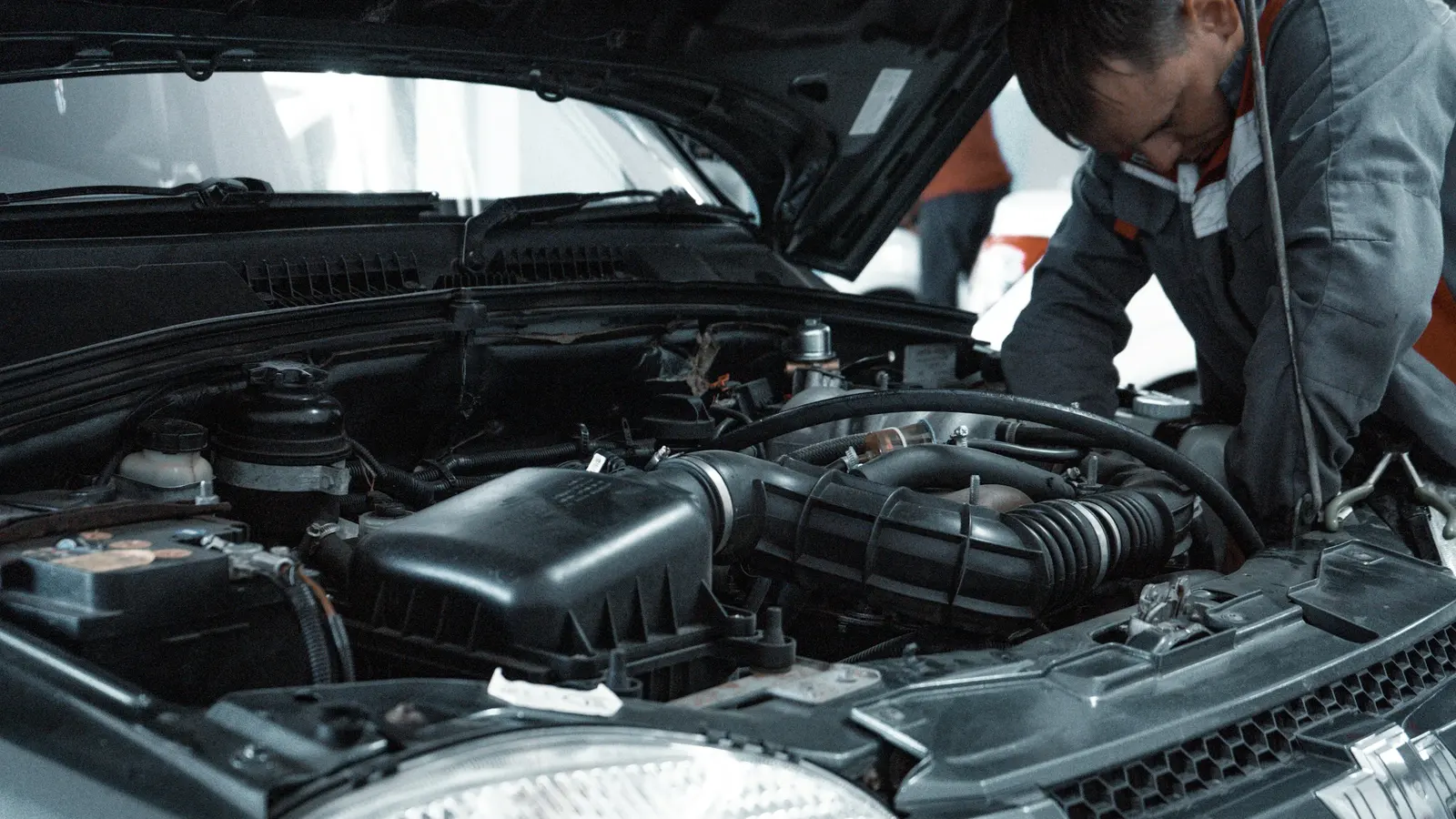 Mecánico trabajando en el motor de un vehículo en un taller. Imagen de referencia.